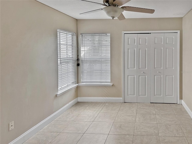 unfurnished bedroom featuring light tile patterned floors, ceiling fan, and a closet