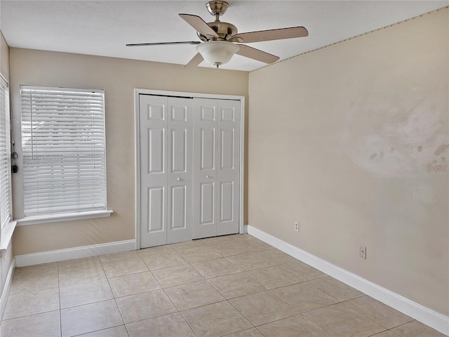 unfurnished bedroom with a closet, ceiling fan, and light tile patterned floors