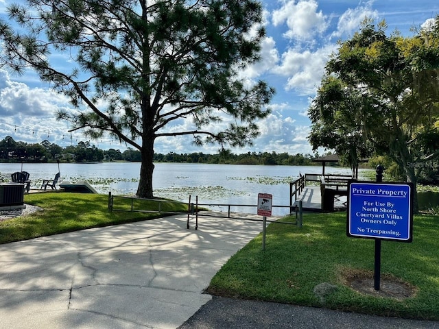 view of property's community featuring a yard and a water view