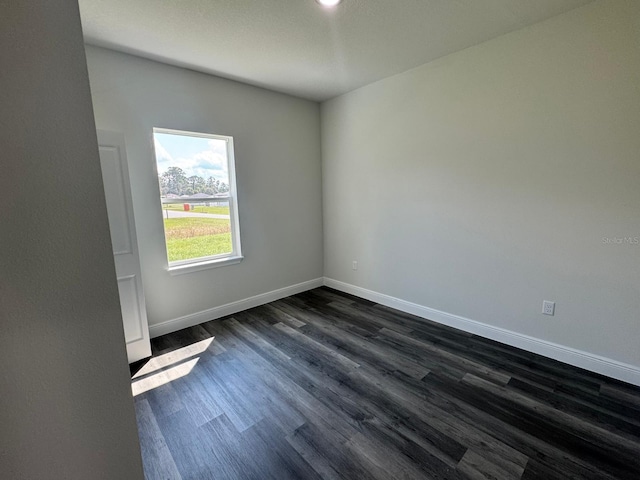 unfurnished room featuring dark wood-type flooring