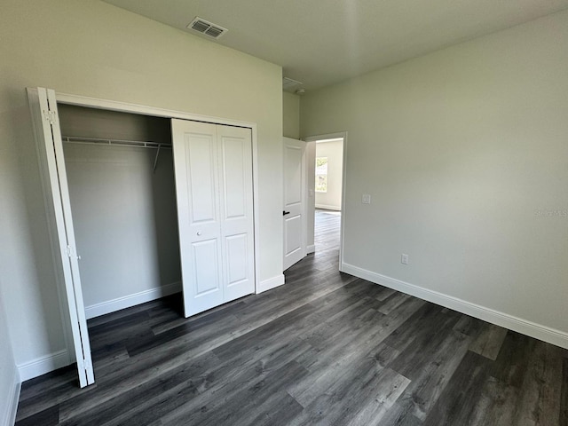 unfurnished bedroom with a closet and dark hardwood / wood-style floors