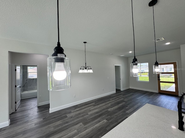 interior space with a textured ceiling, dark wood-type flooring, and a healthy amount of sunlight