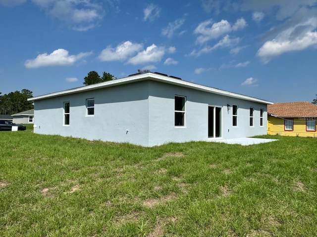 rear view of house featuring a lawn