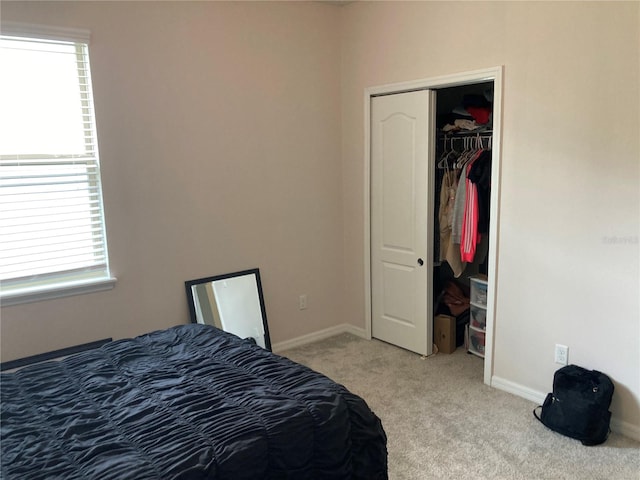 bedroom with light colored carpet and a closet