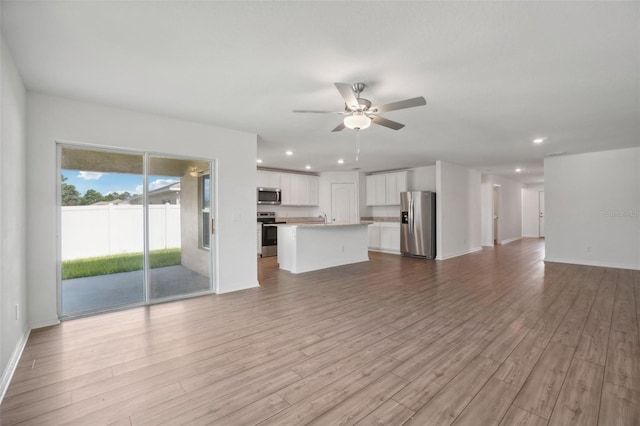 unfurnished living room with ceiling fan and light hardwood / wood-style flooring