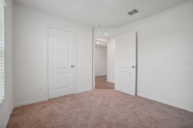 unfurnished bedroom with multiple windows and light colored carpet