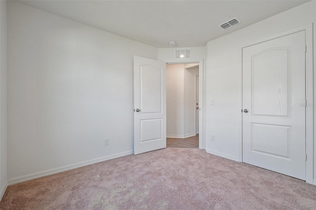 unfurnished bedroom featuring light carpet