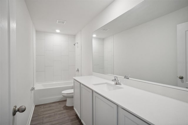 full bathroom featuring tiled shower / bath combo, vanity, hardwood / wood-style floors, and toilet