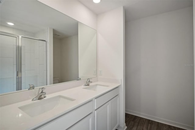 bathroom featuring vanity, wood-type flooring, an enclosed shower, and toilet