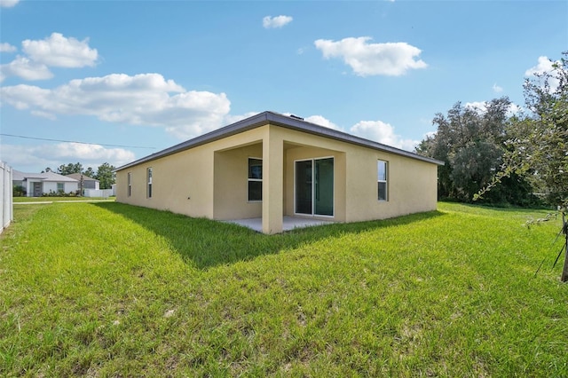 rear view of property featuring a lawn