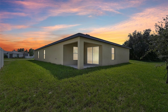 property exterior at dusk with a yard