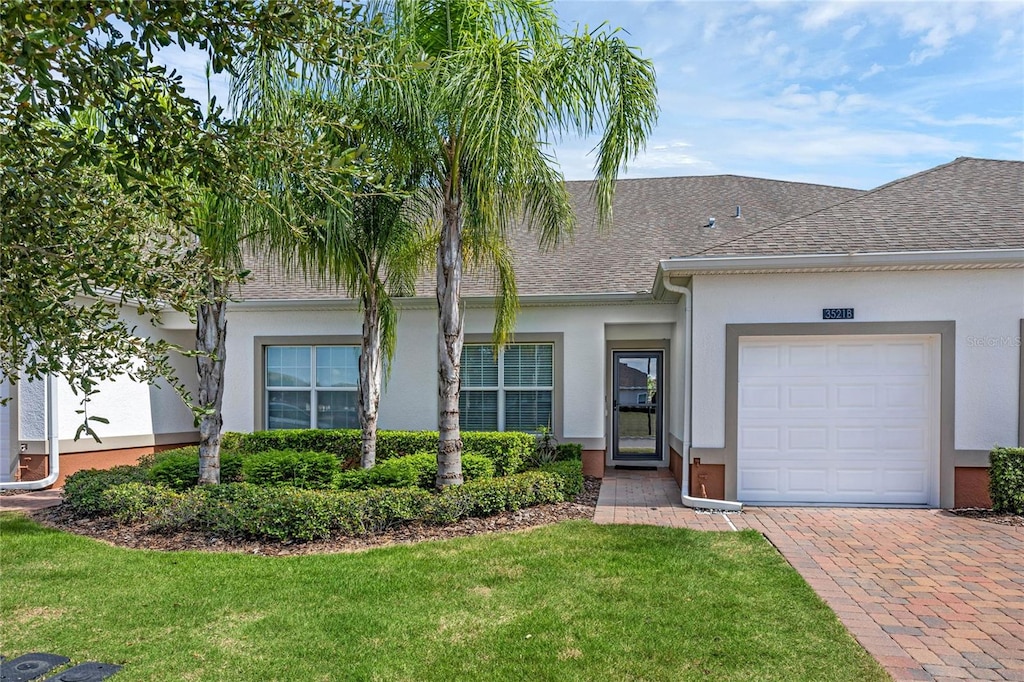 ranch-style home featuring a garage and a front yard