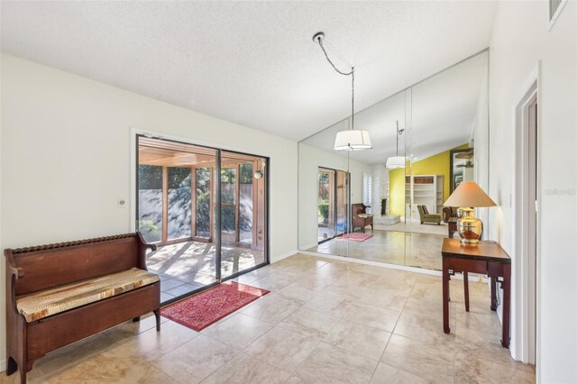 interior space with a textured ceiling and vaulted ceiling