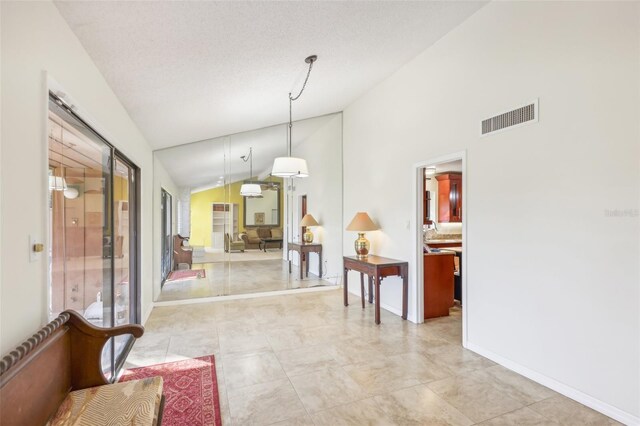 interior space with light tile patterned floors, a textured ceiling, and high vaulted ceiling