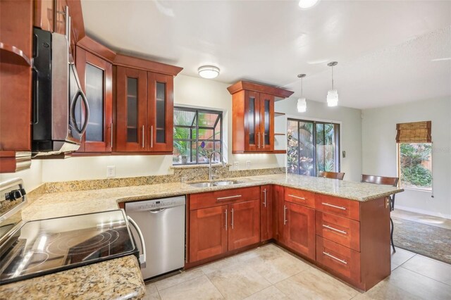 kitchen featuring plenty of natural light, sink, stainless steel appliances, and decorative light fixtures