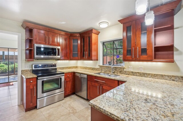 kitchen with sink, hanging light fixtures, light stone countertops, light tile patterned flooring, and stainless steel appliances