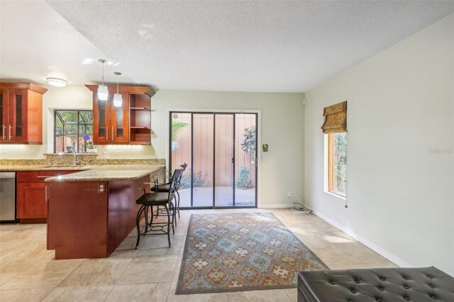 kitchen with light stone countertops, a kitchen breakfast bar, a textured ceiling, decorative light fixtures, and dishwasher