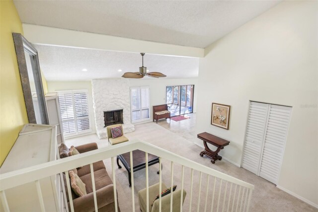 interior space with a fireplace, light colored carpet, ceiling fan, and a healthy amount of sunlight