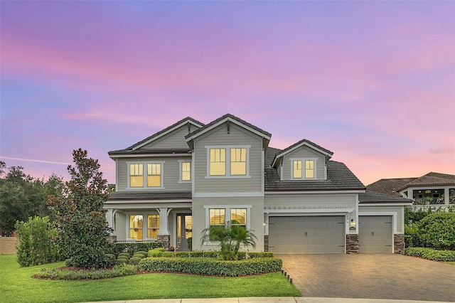 view of front of property with a garage and a lawn