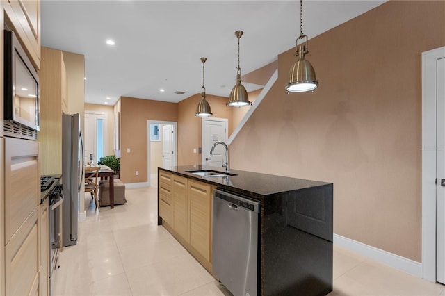 kitchen featuring light brown cabinets, sink, decorative light fixtures, a kitchen island with sink, and appliances with stainless steel finishes