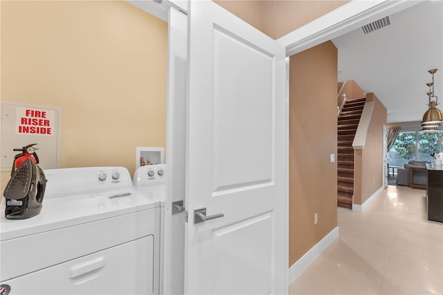 washroom featuring separate washer and dryer and light tile patterned floors