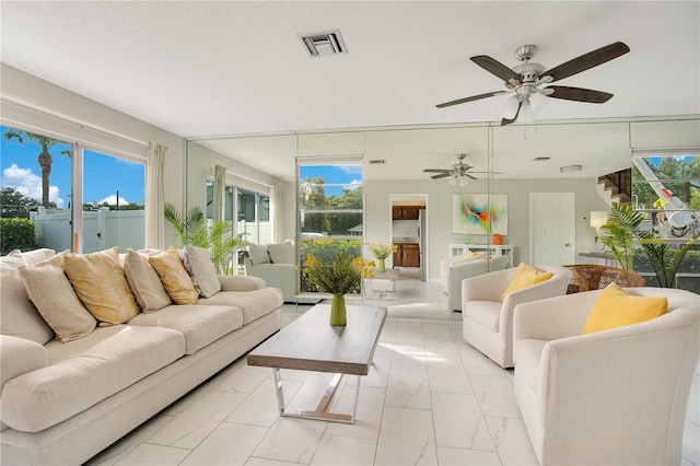 living room with ceiling fan and a textured ceiling