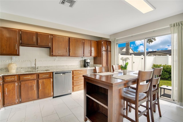 kitchen with dishwasher, light stone counters, tasteful backsplash, and sink