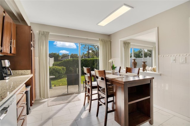 dining space featuring tile walls