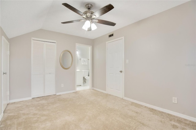 unfurnished bedroom featuring light carpet, a closet, lofted ceiling, and ceiling fan