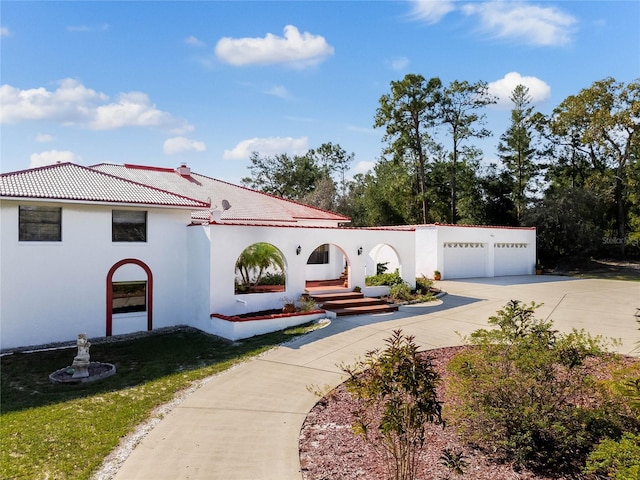 mediterranean / spanish home with a front lawn and a garage