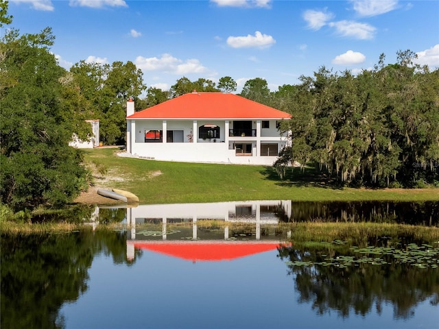 back of house featuring a yard and a water view