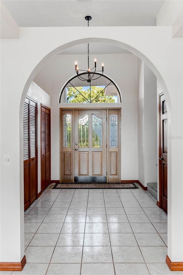 tiled foyer entrance featuring a chandelier