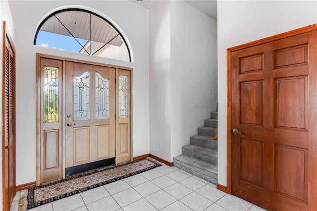 foyer featuring light tile patterned floors and a high ceiling