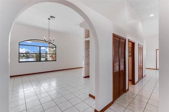 hall featuring an inviting chandelier and light tile patterned flooring