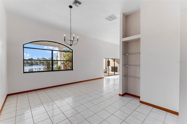 tiled empty room with an inviting chandelier, a water view, and built in features