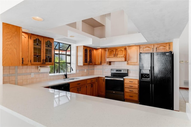 kitchen featuring sink, black appliances, custom range hood, and backsplash