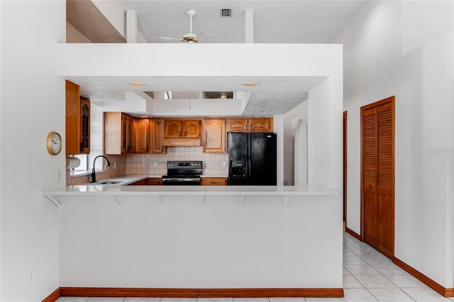 kitchen with sink, light tile patterned flooring, black refrigerator with ice dispenser, kitchen peninsula, and stainless steel electric range oven