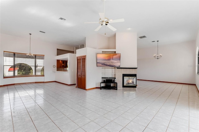 unfurnished living room featuring a tiled fireplace, light tile patterned flooring, and ceiling fan with notable chandelier