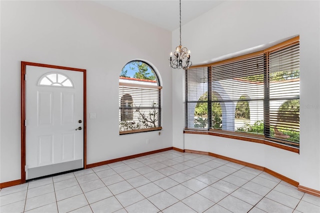 foyer entrance with light tile patterned floors, a chandelier, and plenty of natural light