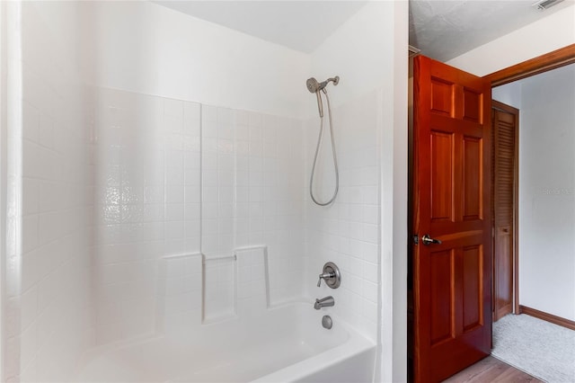 bathroom with hardwood / wood-style floors and shower / tub combo