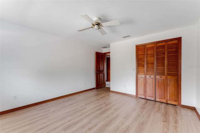 unfurnished bedroom with light hardwood / wood-style floors, a closet, and ceiling fan