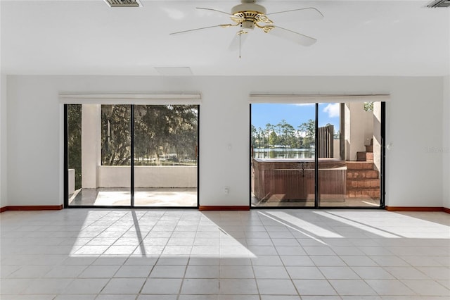 tiled empty room featuring ceiling fan