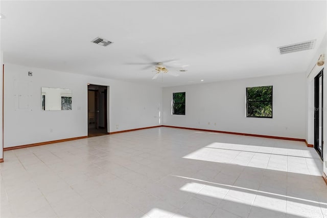 unfurnished room featuring ceiling fan and a wealth of natural light