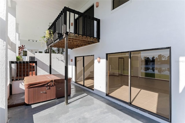 interior space with a balcony and a hot tub