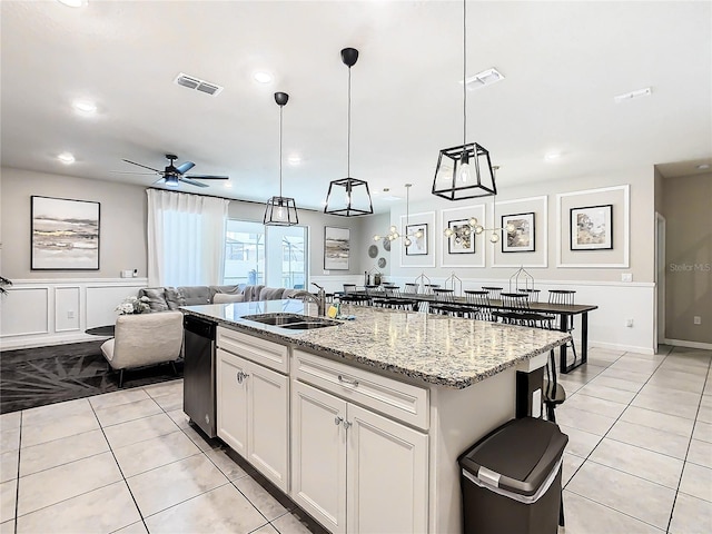 kitchen with sink, an island with sink, white cabinets, hanging light fixtures, and ceiling fan