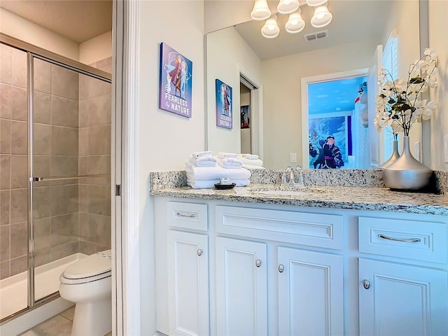 bathroom with vanity, a shower with shower door, toilet, and tile patterned floors