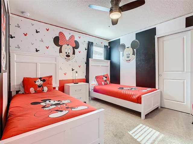 bedroom featuring a textured ceiling, ceiling fan, and light colored carpet