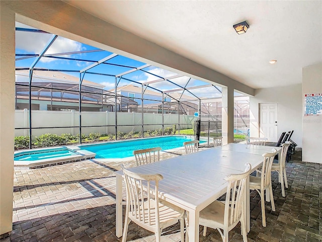 view of swimming pool with a patio, glass enclosure, and an in ground hot tub