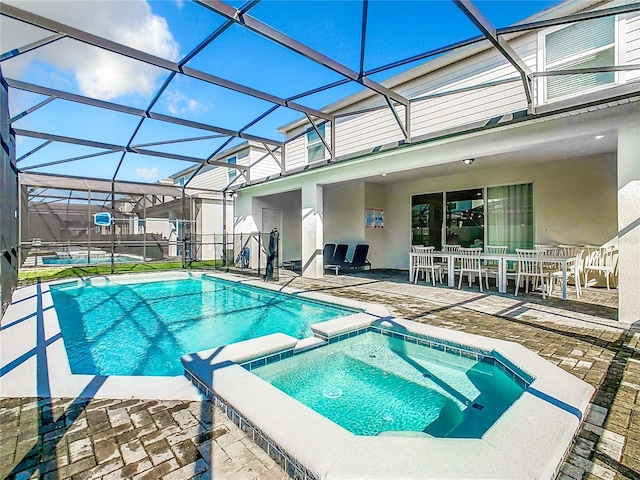 view of swimming pool featuring a lanai, an in ground hot tub, and a patio area