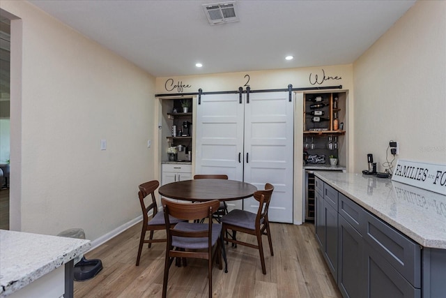 dining space featuring a barn door and light hardwood / wood-style flooring